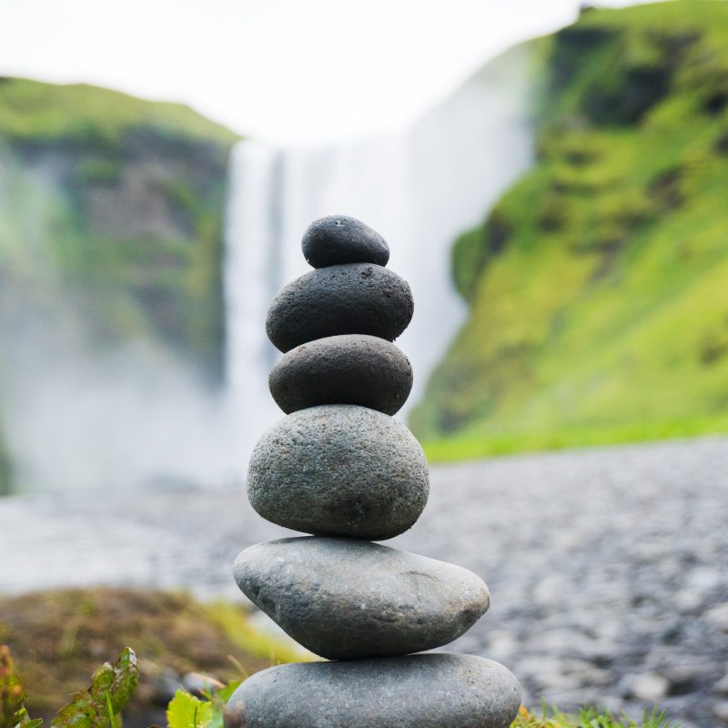 pebbles balanced against view of waterfall